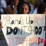 A girl holding a sign and protesting justice for Michael Brown. Photo Courtesy of NY Daily News